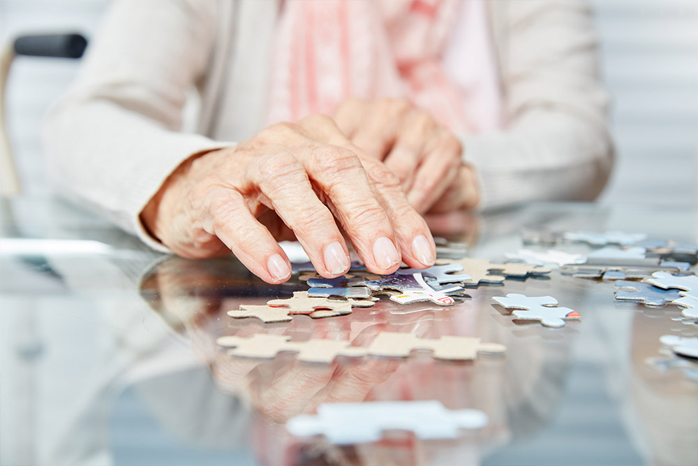 Elderly woman doing jigsaw puzzle